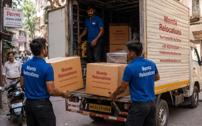 Movers loading cartons into a tempo on a congested Mumbai lane — Mamta Relocations