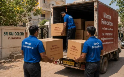 Movers loading cartons outside a Vijayawada colony under a hot sun — Mamta Relocations