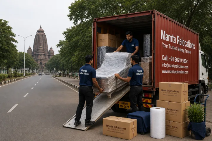 Mamta Relocations crew loading stretch-wrapped furniture and labelled cartons into their truck on a wide tree-lined planned road in Bhubaneswar